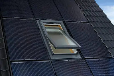 Dakraam tussen zonnepanelen op een donker pannendak