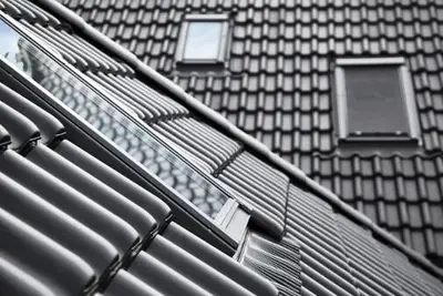 Dakramen op verschillende dakvlakken tussen donkere dakpannen