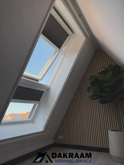 VELUX combi-dakraam met rolgordijnen en witte aftimmering naast een houten lattenwand